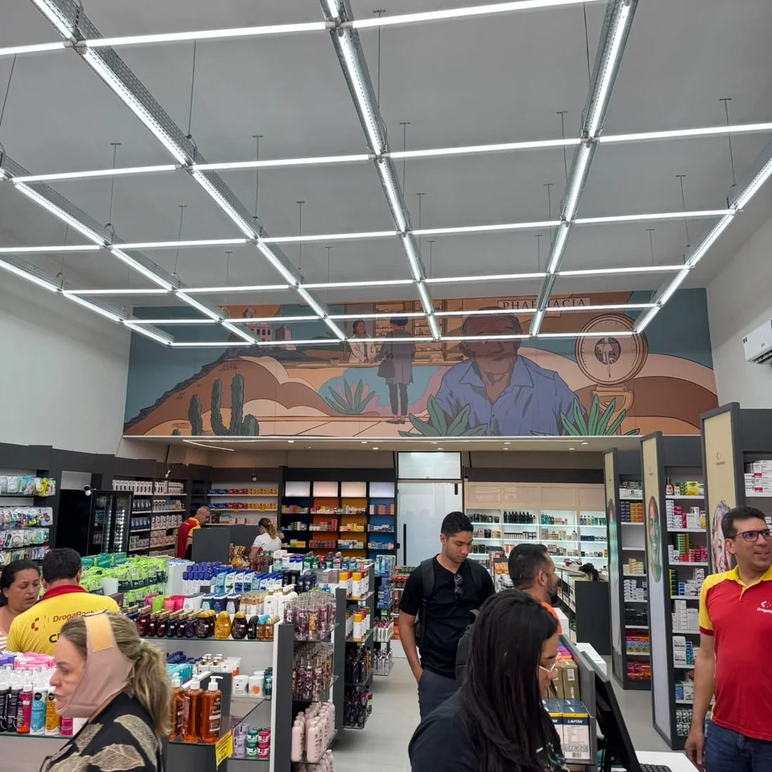 Interior da DrogaRocha, com a equipe e clientes na loja